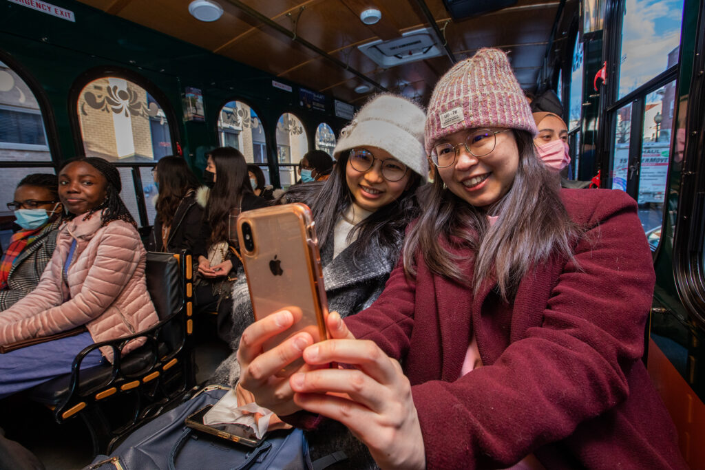 Two students take a selfie while on a bus trip