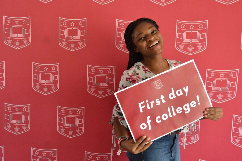 A student poses with a sign on the first day of class